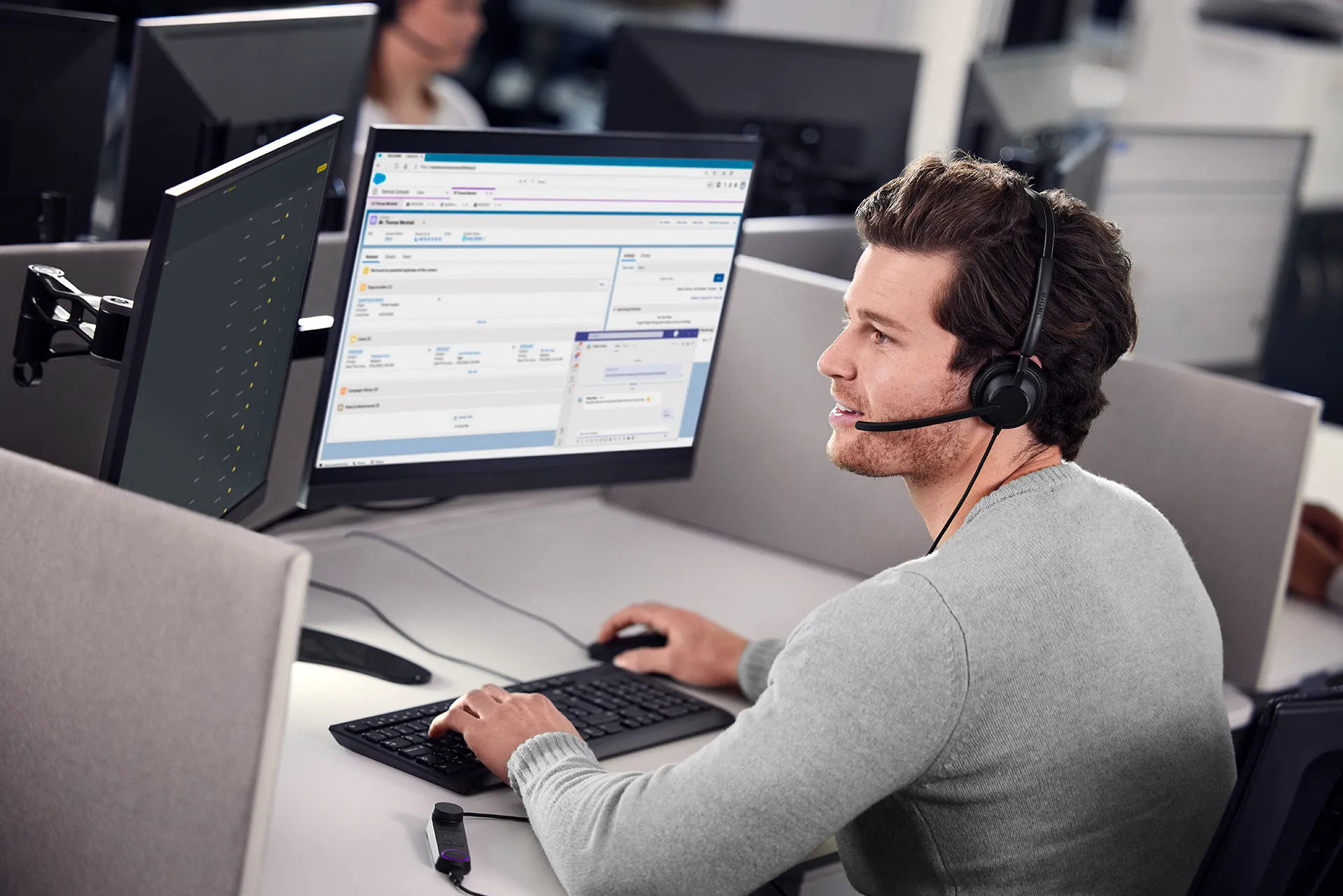 A male office worker using a Jabra Engage 50 II headset while focused on his computer work